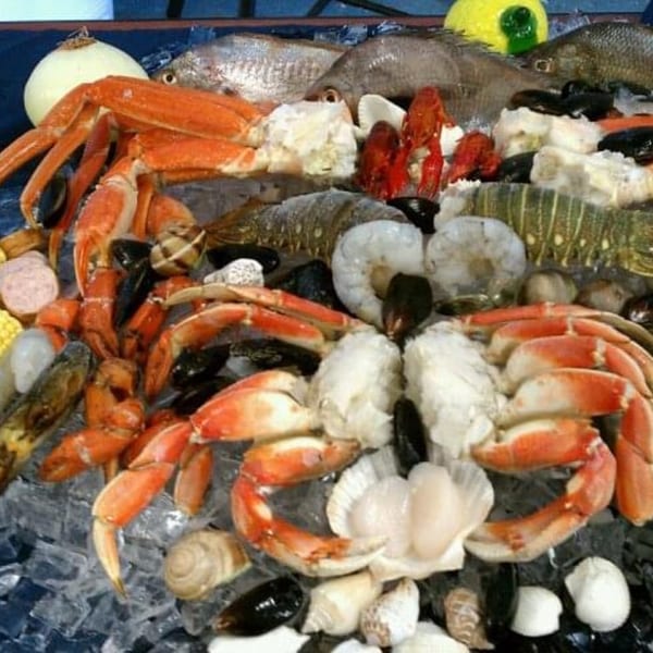 A vibrant seafood display on ice, featuring crabs, fish, shrimp, mussels, and scallops.