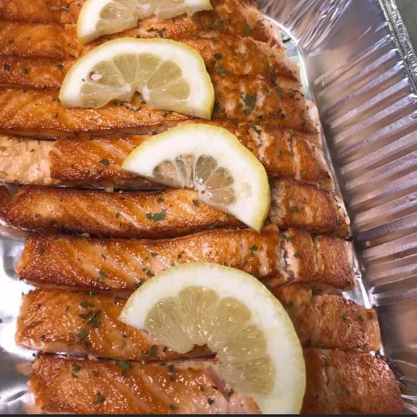 Baked salmon fillets with herbs and lemon slices in a foil pan from A'Nets Katch.